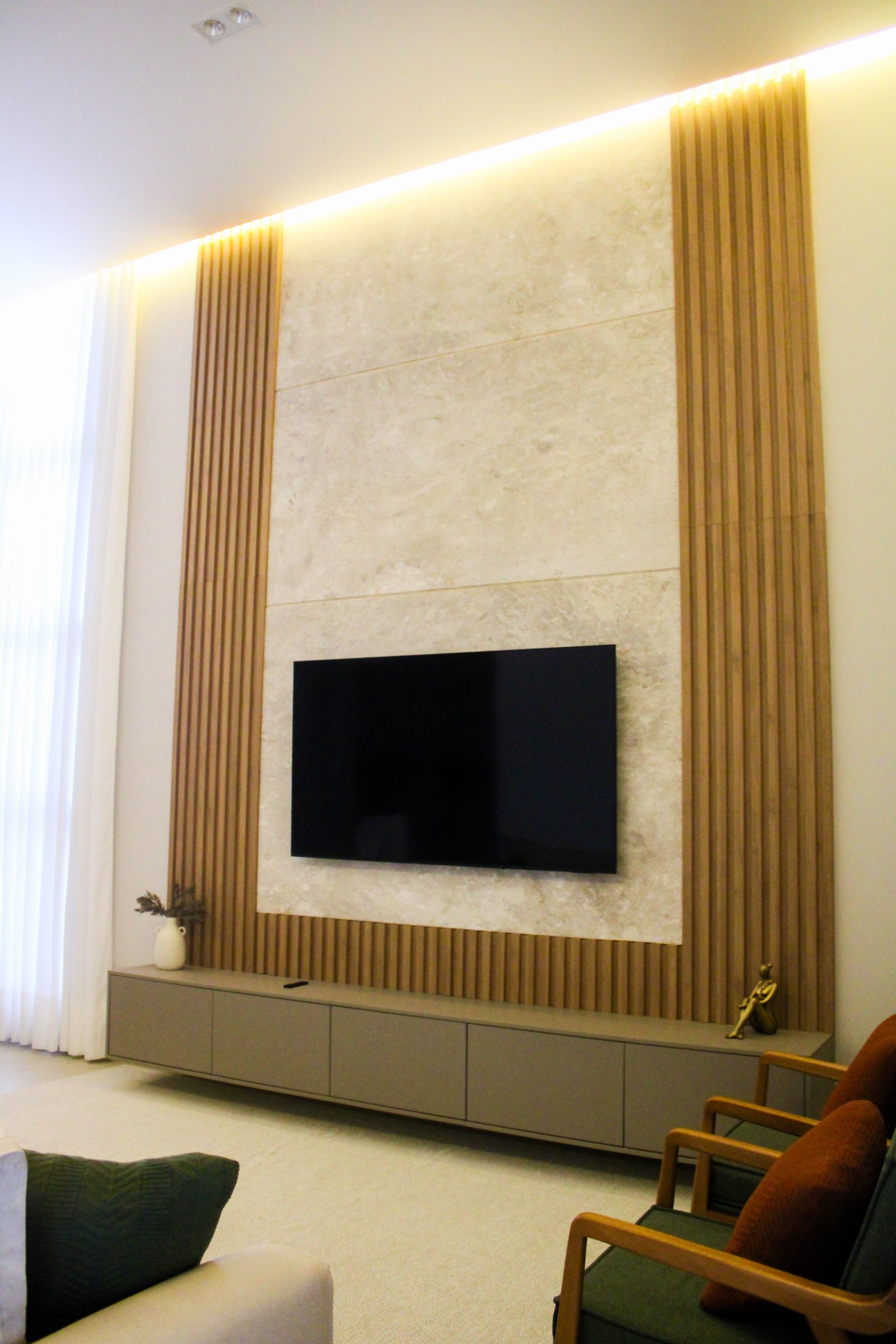 Sala de estar com painel ripado assinada pela Grid